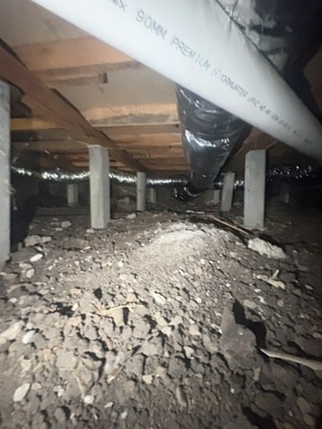 Subfloor view showing timber floor framing, supports, pipework and ducting